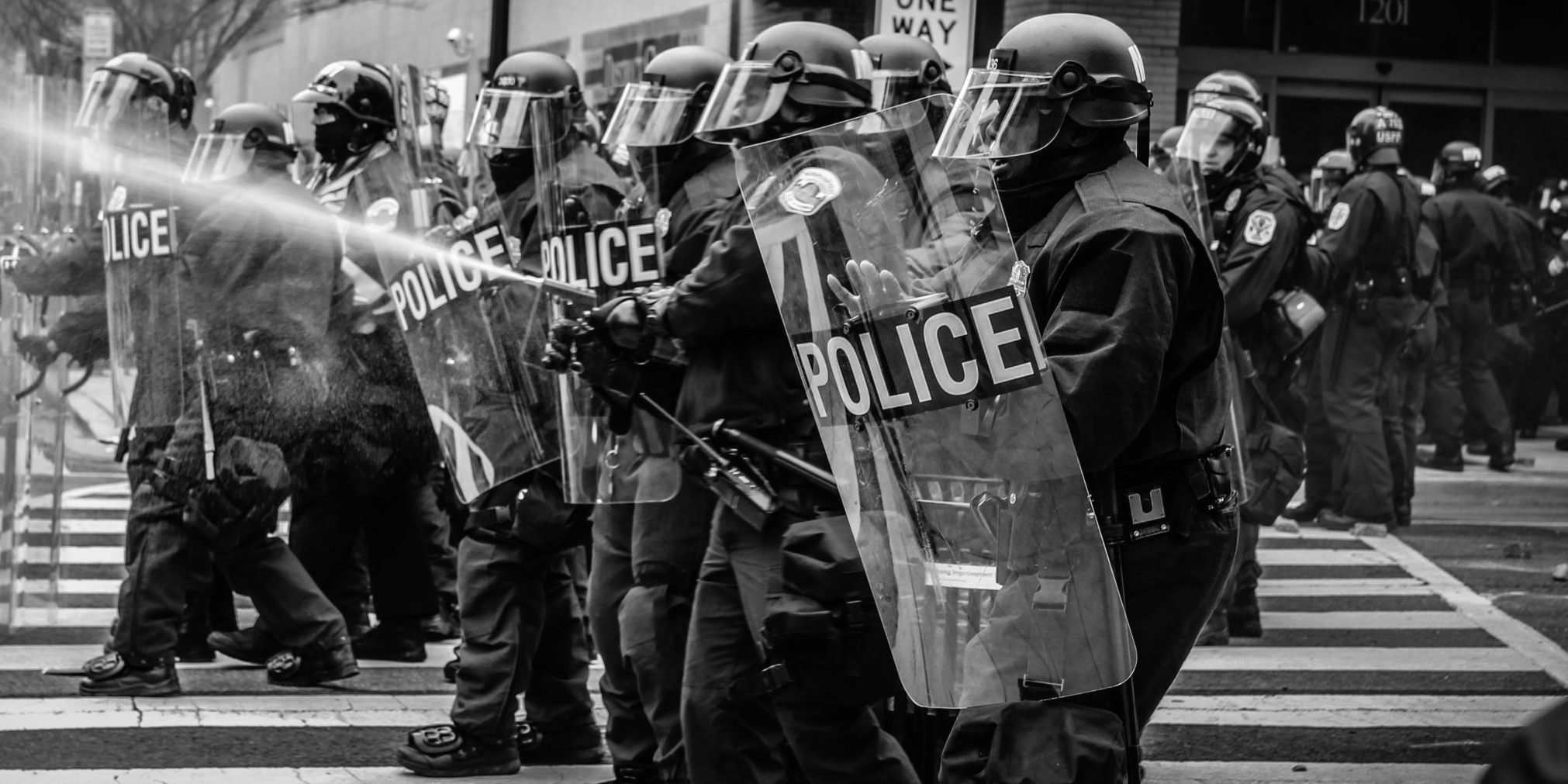 grayscale photo of police riot team on pedestrian lane