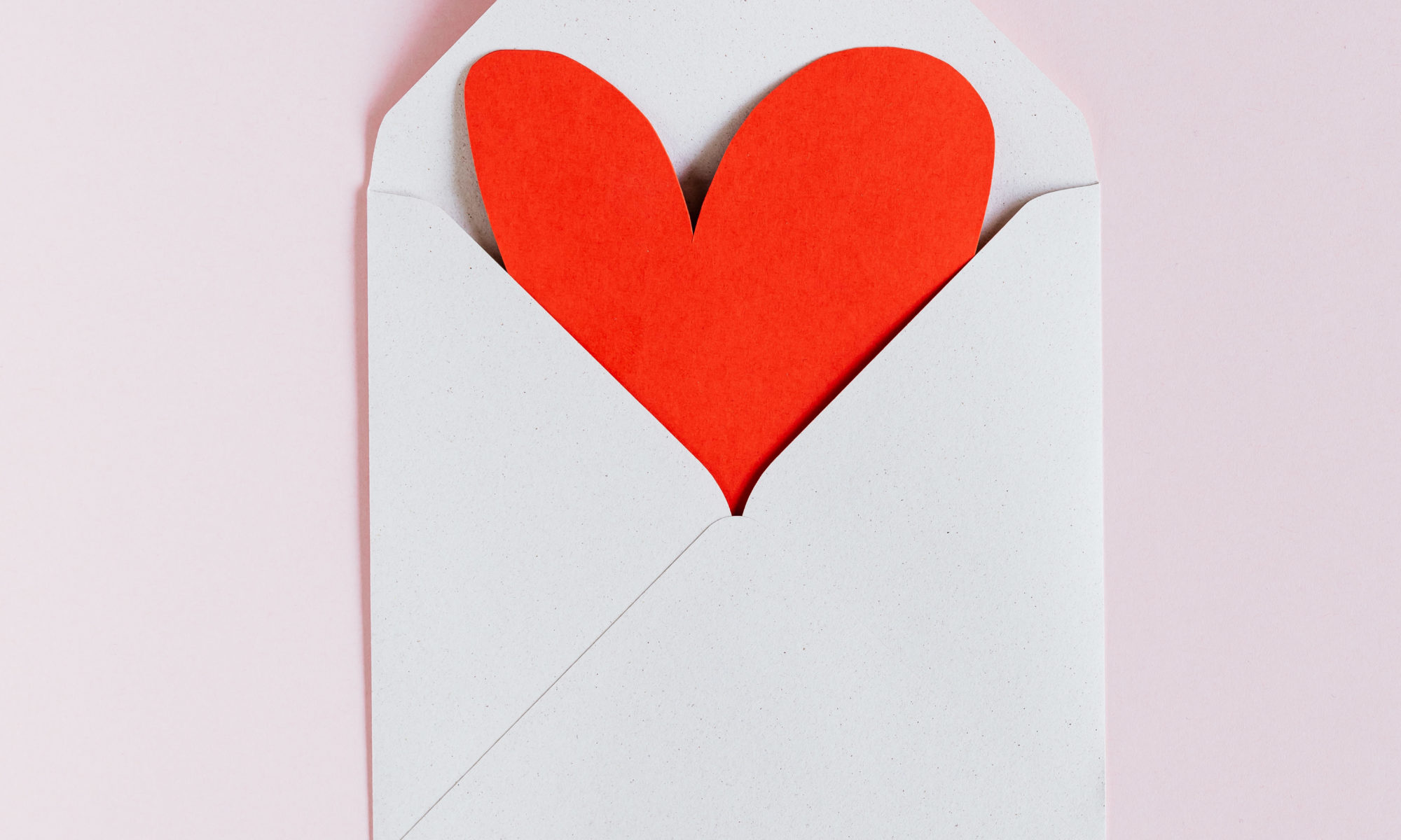 White envelope with red paper heart